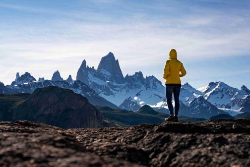 Alone hiker with yellow jacket admiring views over Mount Fitz Ro